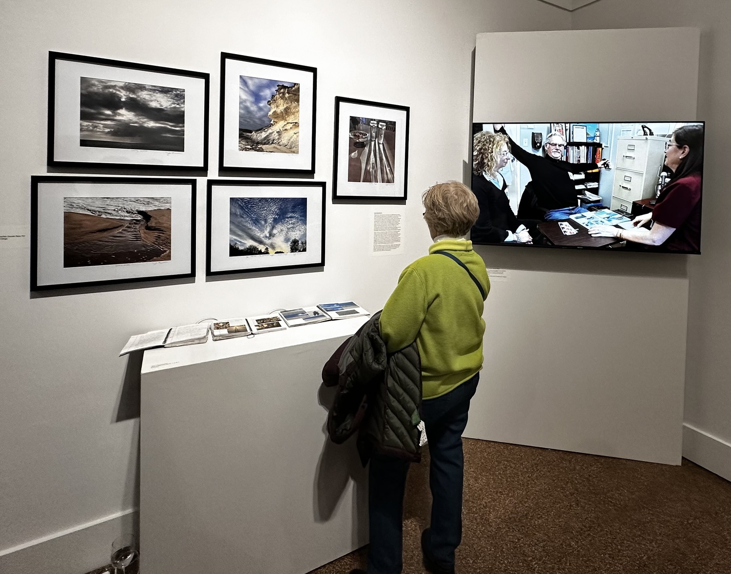 A visitor admires John Buchbinder's photography, which is on view as part of the exhibit 