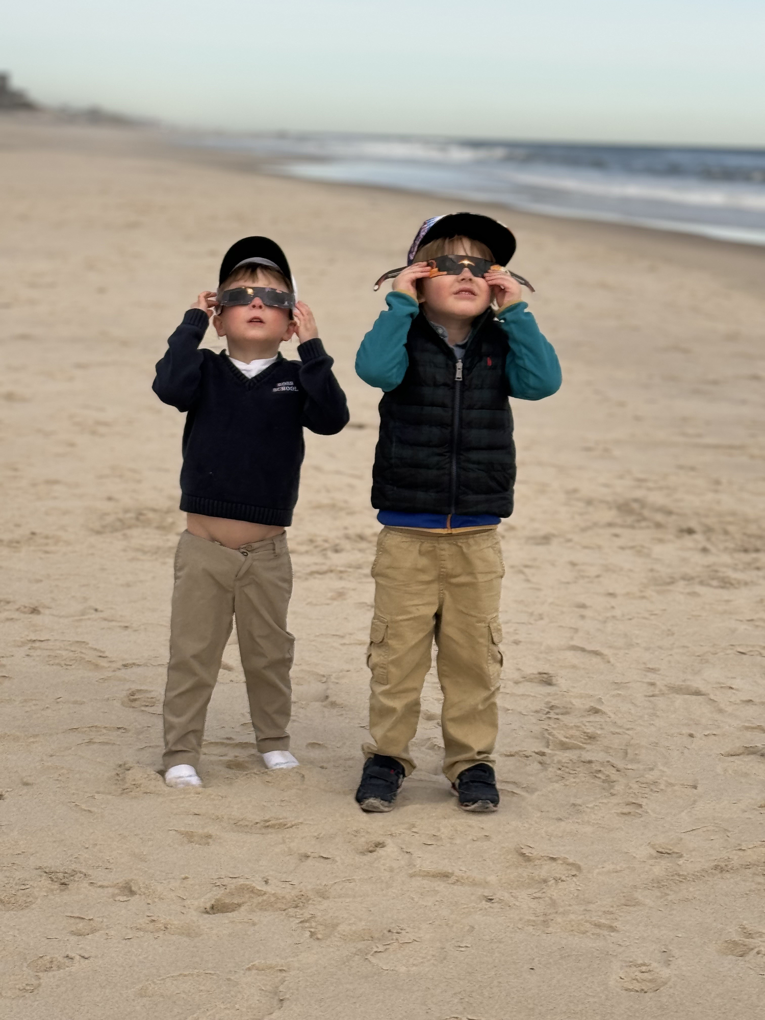 Jack Cosgrove and Beckett Murray watch the eclipse at Little Plains Beach in Southampton Village on Monday afternoon. COURTESY JOHN COSGROVE