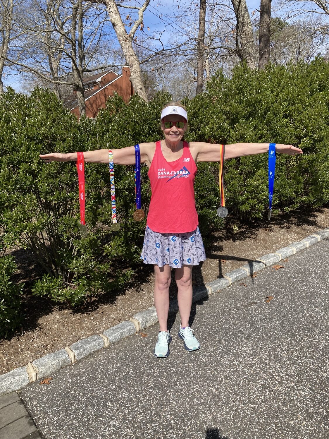 Gail Miranda of Hampton Bays with the five medals she earned from completing five of the six major marathon around the world, which includes New York City, Chicago, London, Berlin and Tokyo.   COURTESY GAIL MIRANDA