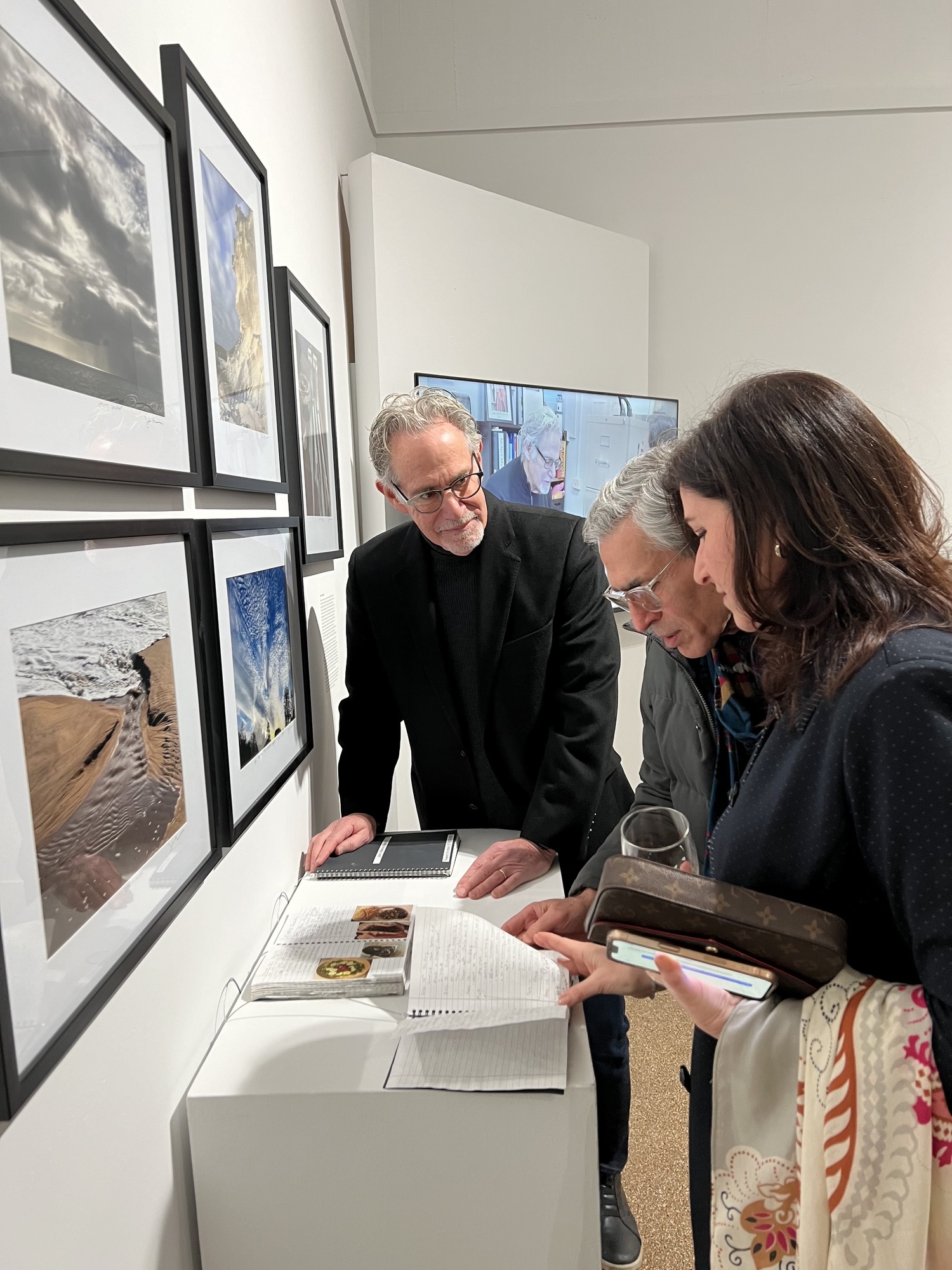 Peter Strugatz flips through one of John Buchbinder's memory books, on view at the Southampton Arts Center in the exhibition 