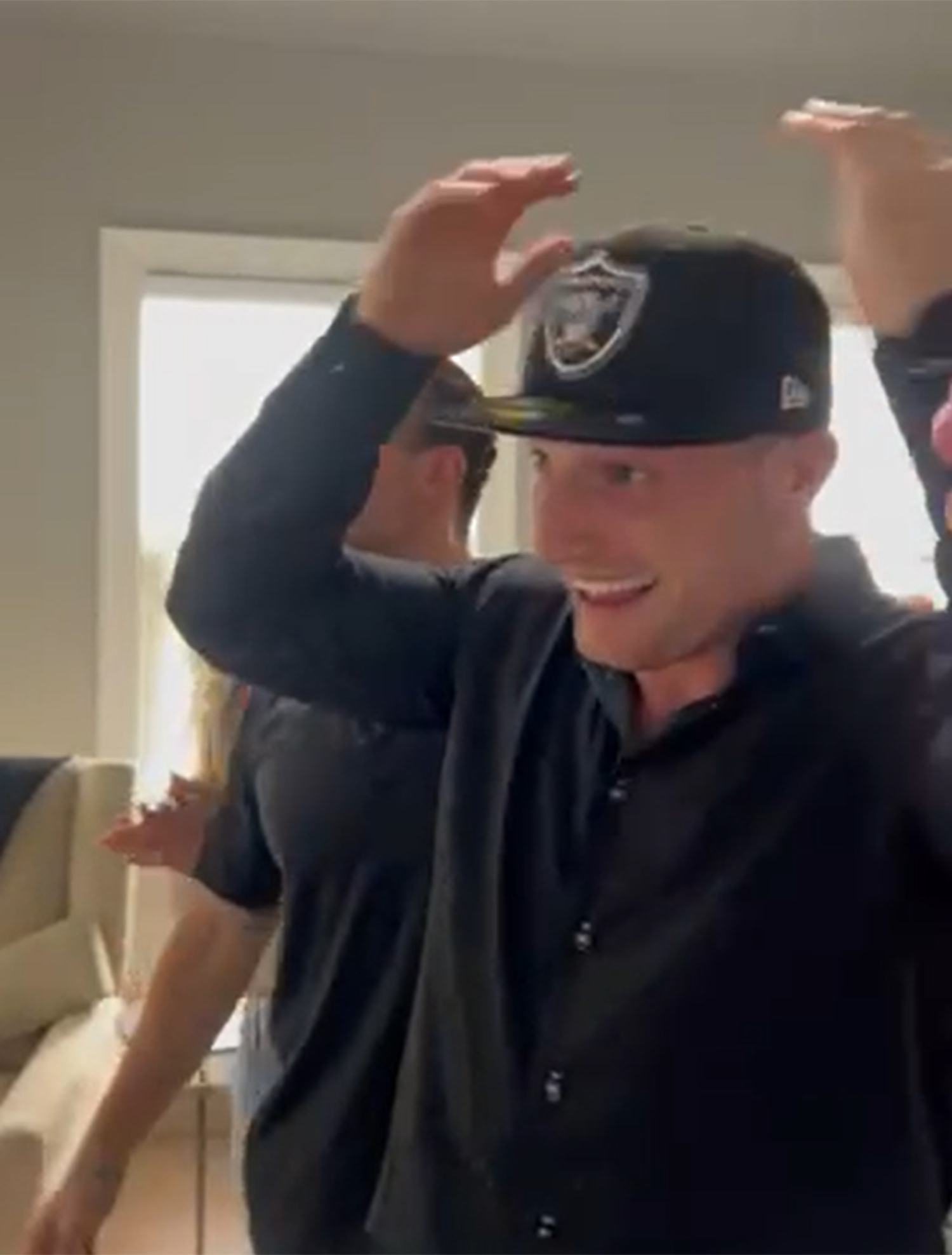 Dylan Laube puts on a Las Vegas Raiders hat for the first time.
