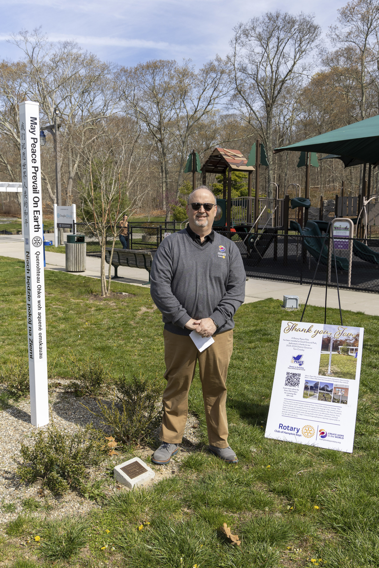 Tom Crowley of Hampton Bays, a 37-year member of the hamlet’s Rotary Club, was honored on Saturday with the dedication of a peace pole “May peace prevail on Earth,” in eight languages, at Good Ground Park.  MICHAEL O'CONNOR