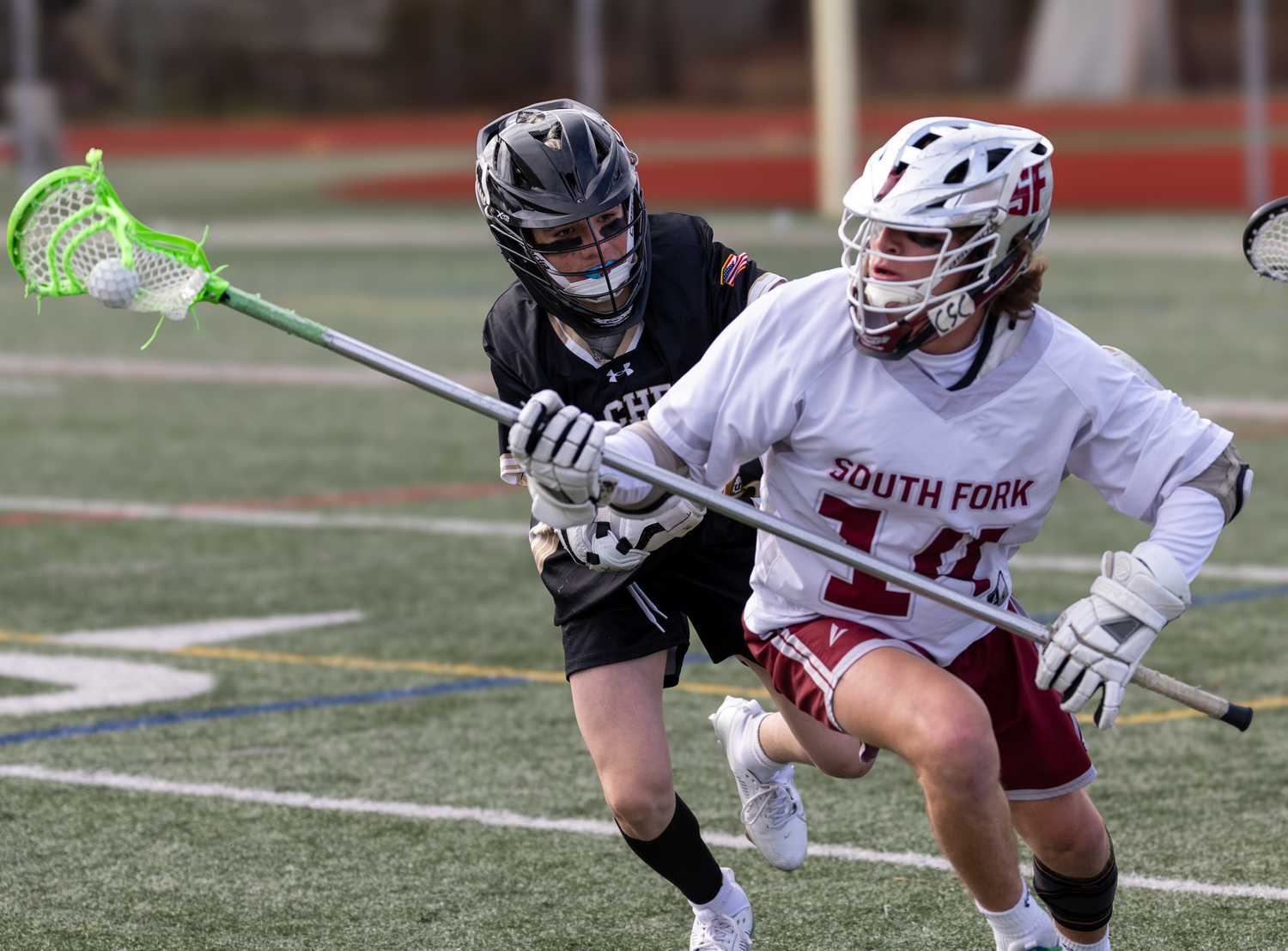 South Fork's Luke Castillo picks up a ground ball with a Sachem North player on his back.  RON ESPOSITO