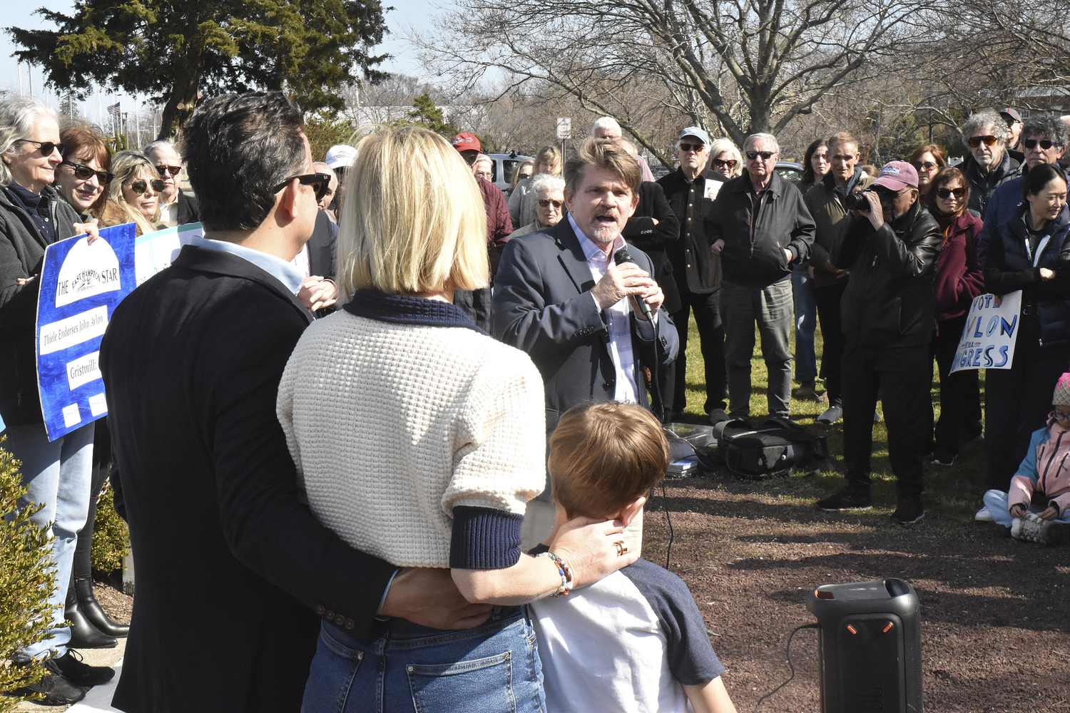 Southampton Town Councilman Tommy John Schiavoni, who is running for the State Assembly, speaks while congressional candidate John Avlon and his family look on at a rally in Sag Harbor in March. STEPHEN J. KOTZ