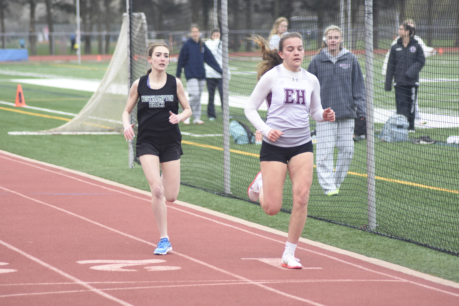 Sophia DiPierro tries to take Greylynn Guyer at the finish line of the 800-meter run at a dual meet at East Hampton on April 19. DREW BUDD
