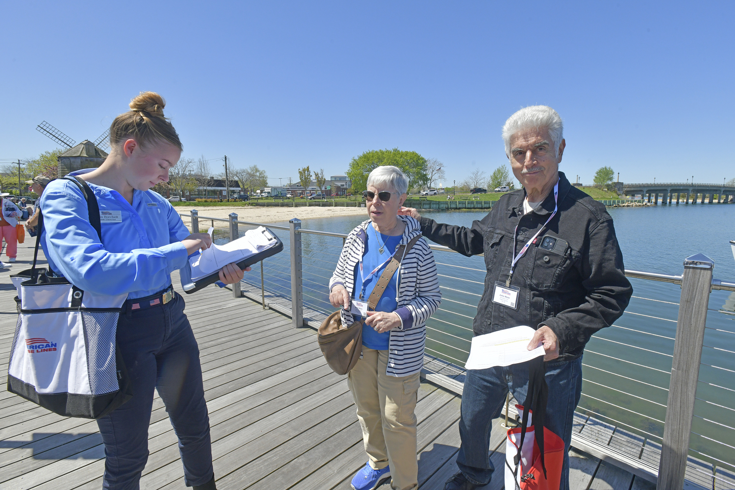American Cruise Line passengers Beth and John Klein check in with cruise and excursion director Karis Borchelt as they wait for their launch back to their ship at the dock in Sag Harbor on Tuesday.