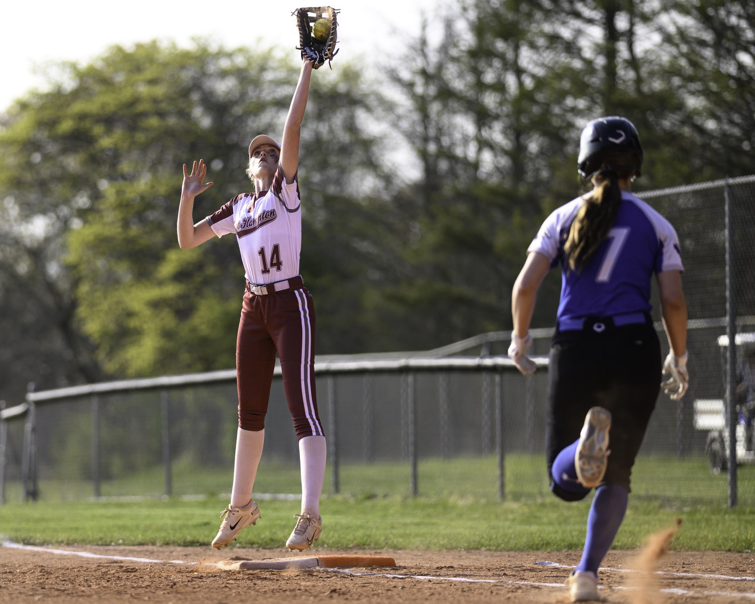 Maryjane Vickers leaps to catch a
throw at first base.  MARIANNE BARNETT