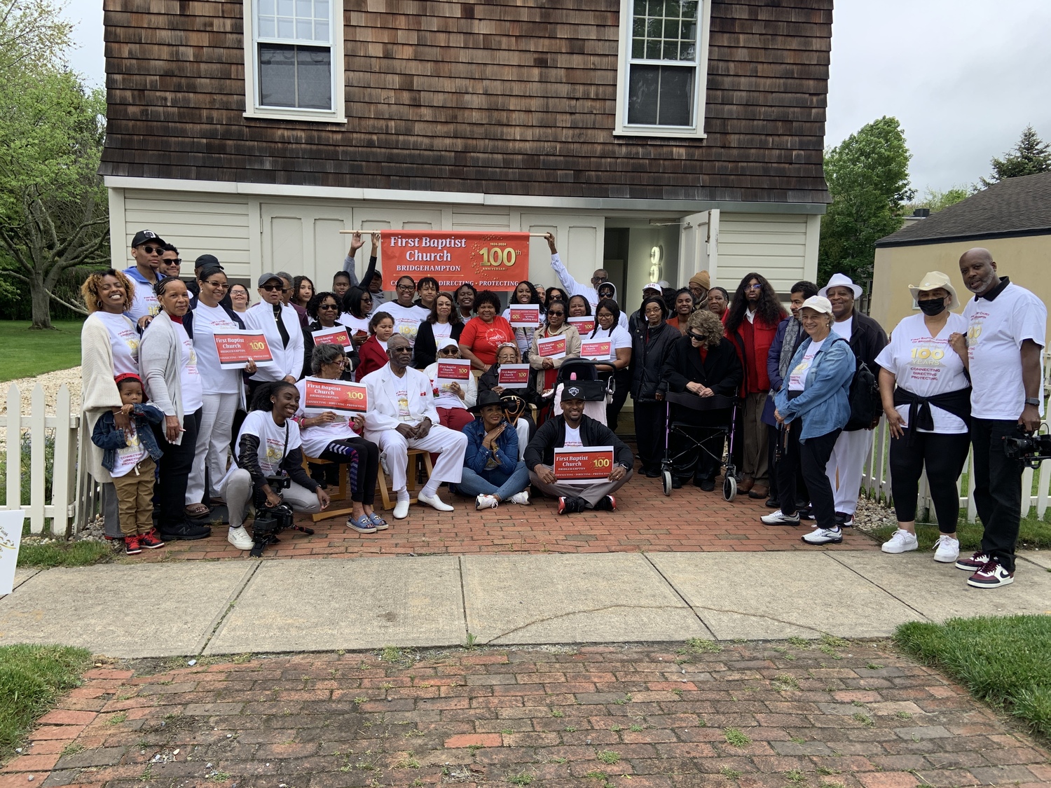 Members of the First Baptist Church of Bridgehampton gather at the congregation's first home on Corwith Avenue before marching to their current church on the Bridgehampton-Sag Harbor Turnpike Sunday, May 19. STEPHEN J. KOTZ