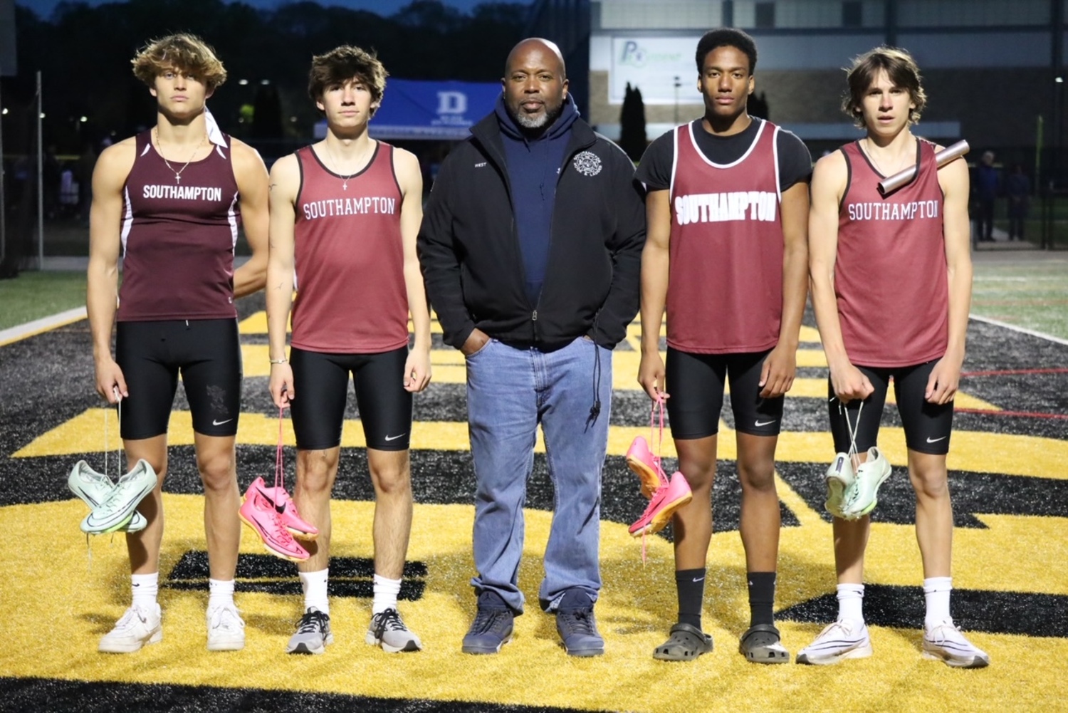 Southampton's 4x100-meter relay team of Hudson Fox, left, Jett De Sane, relay coach Eddie West, Davon Palmore and Tanner Marro. The squad broke the previous school record from 2005.   JAMIE CARLSEN