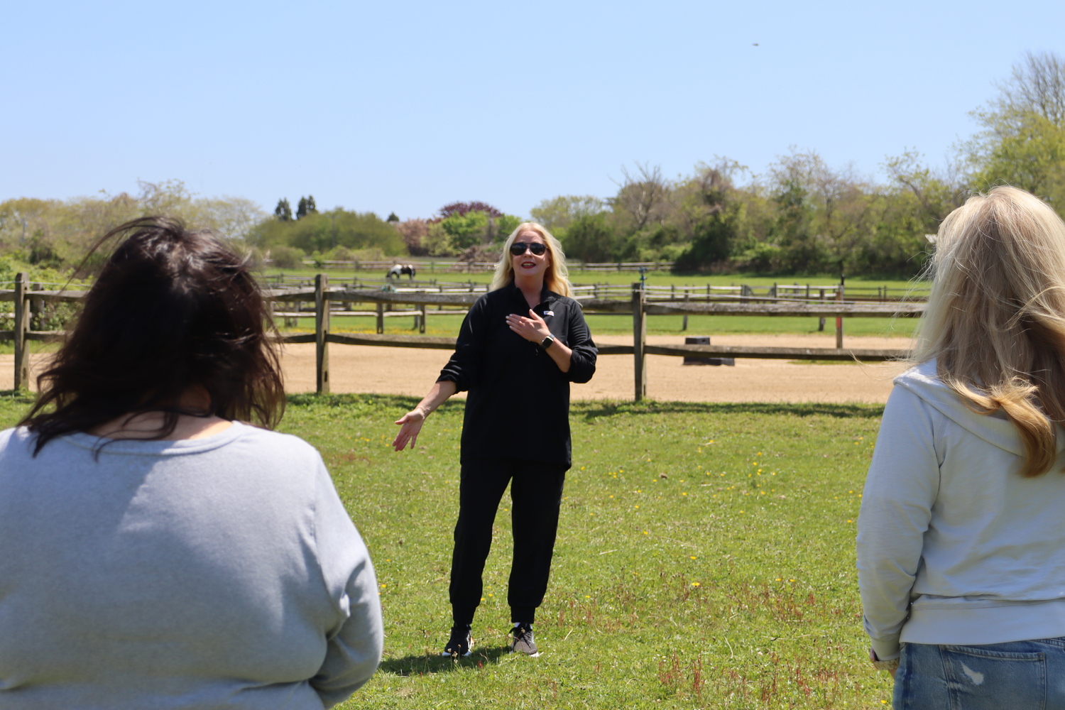 Tracie Sullivan, a cancer exercise specialist with Stony Brook Southampton Hospital, leads the women through a series of movements to warm up before they being grooming the horses. CAILIN RILEY