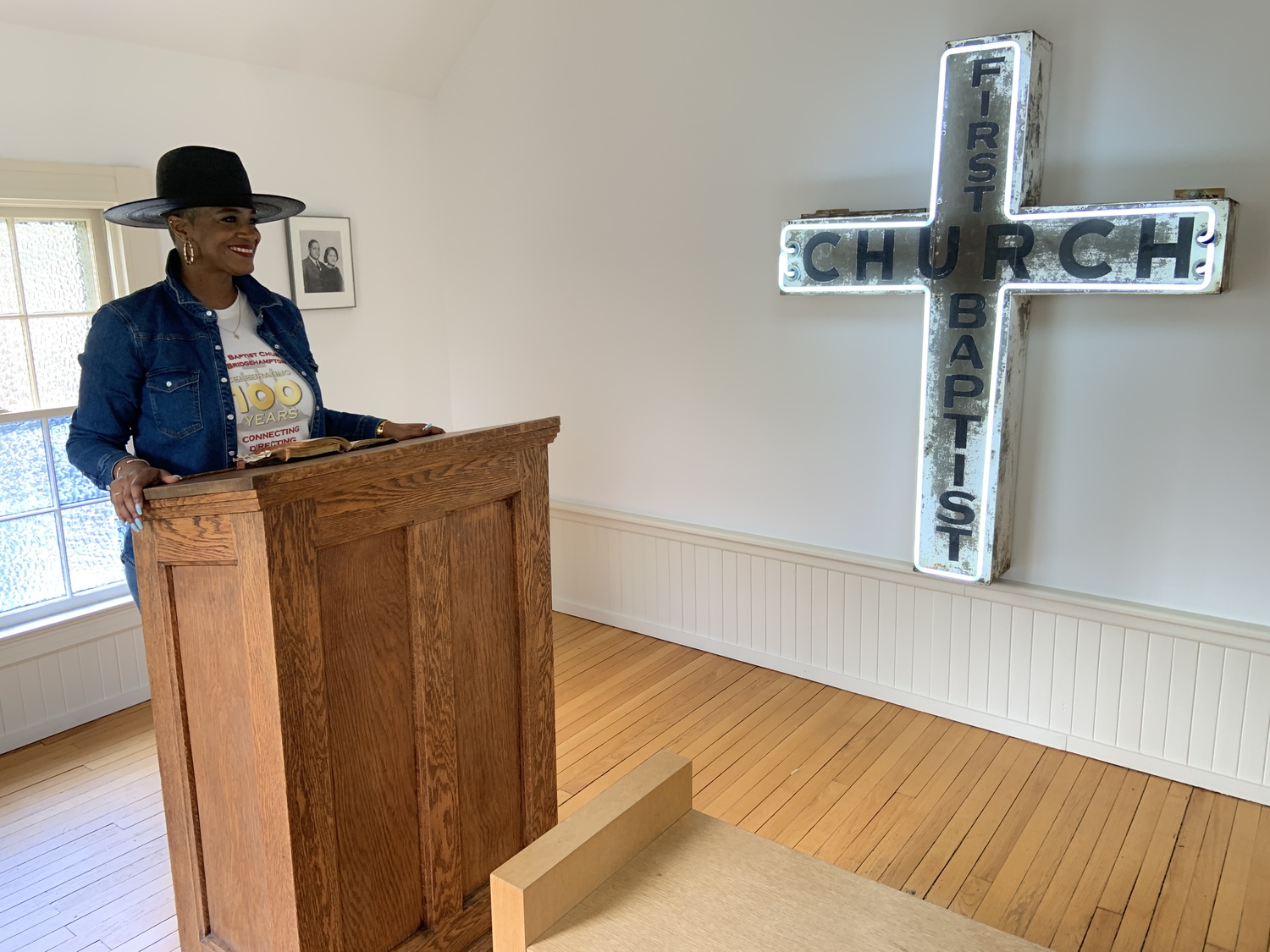 The Reverend Tisha Williams at the original church pulpit next to its original sign, which are on display at  Dia Bridgehampton/The Dan Flavin Art Institute. STEPHEN J. KOTZ
