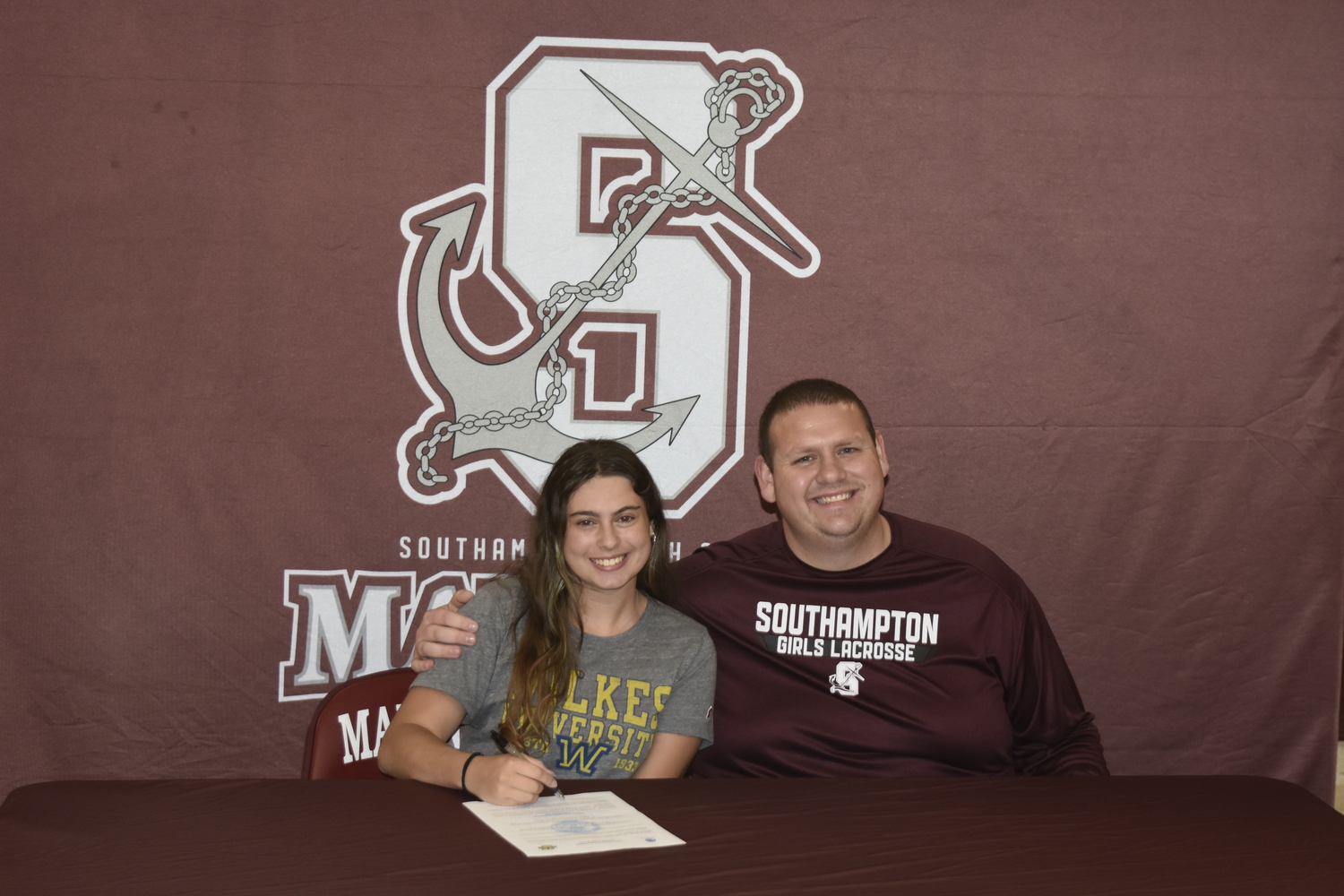 Chloe Bierfriend with varsity girls lacrosse head coach Ryan Sommers.   DREW BUDD