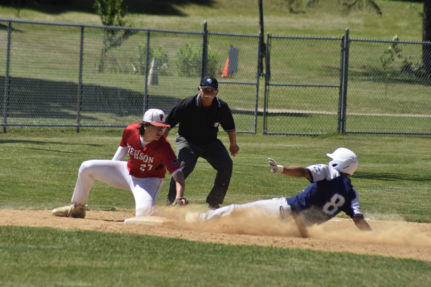Pierson third baseman Charles Schaefer tags out a Burke Catholic player trying to steal third base.   DREW BUDD