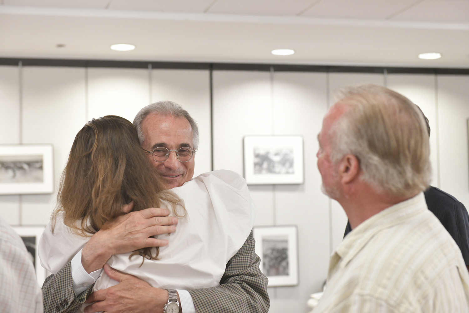 Newly elected Southampton Village Trustee Ed Simioni hugs Kimberly Allan  as former Southampton Village Mayor Michael Irving looks onafter the election results were read on Friday night.  DANA SHAW