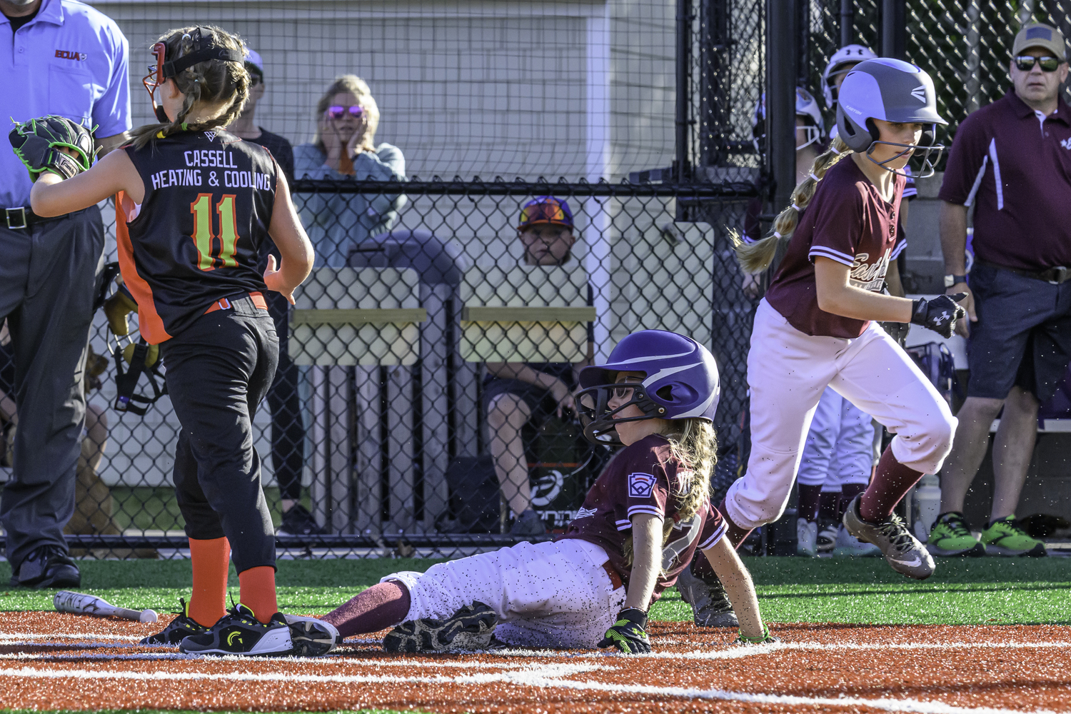 Charlotte Vickers slides safely into home plate as Avery Dalene heads to first. MARIANNE BARNETT