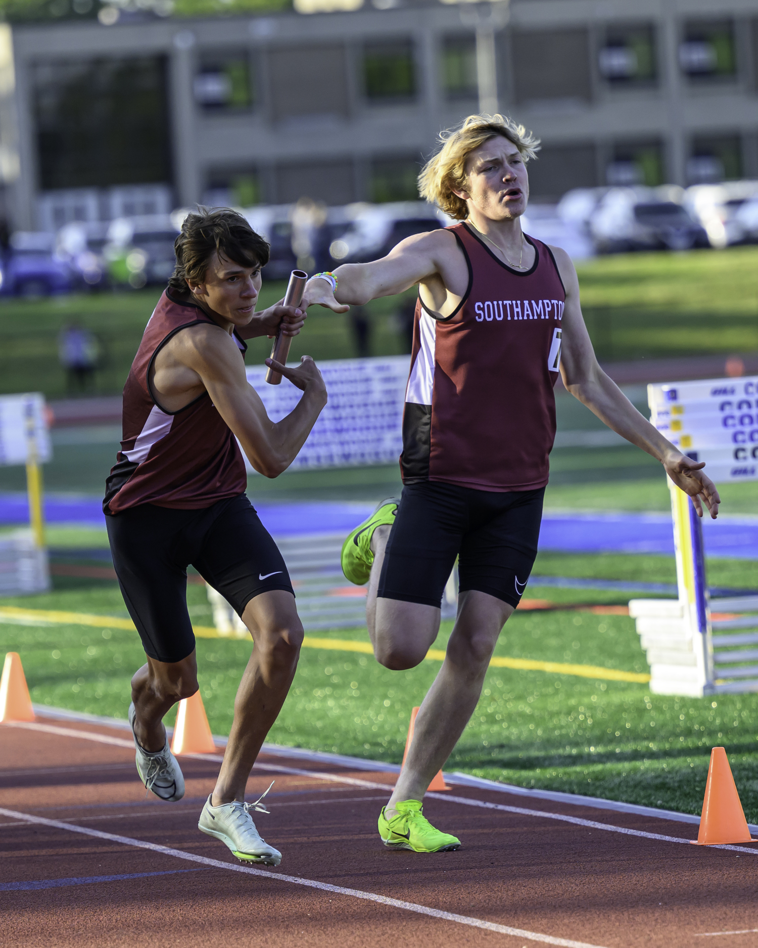 Tanner Marro takes the baton from Ronan Brady in the boys 4x400-meter relay.   MARIANNE BARNETT