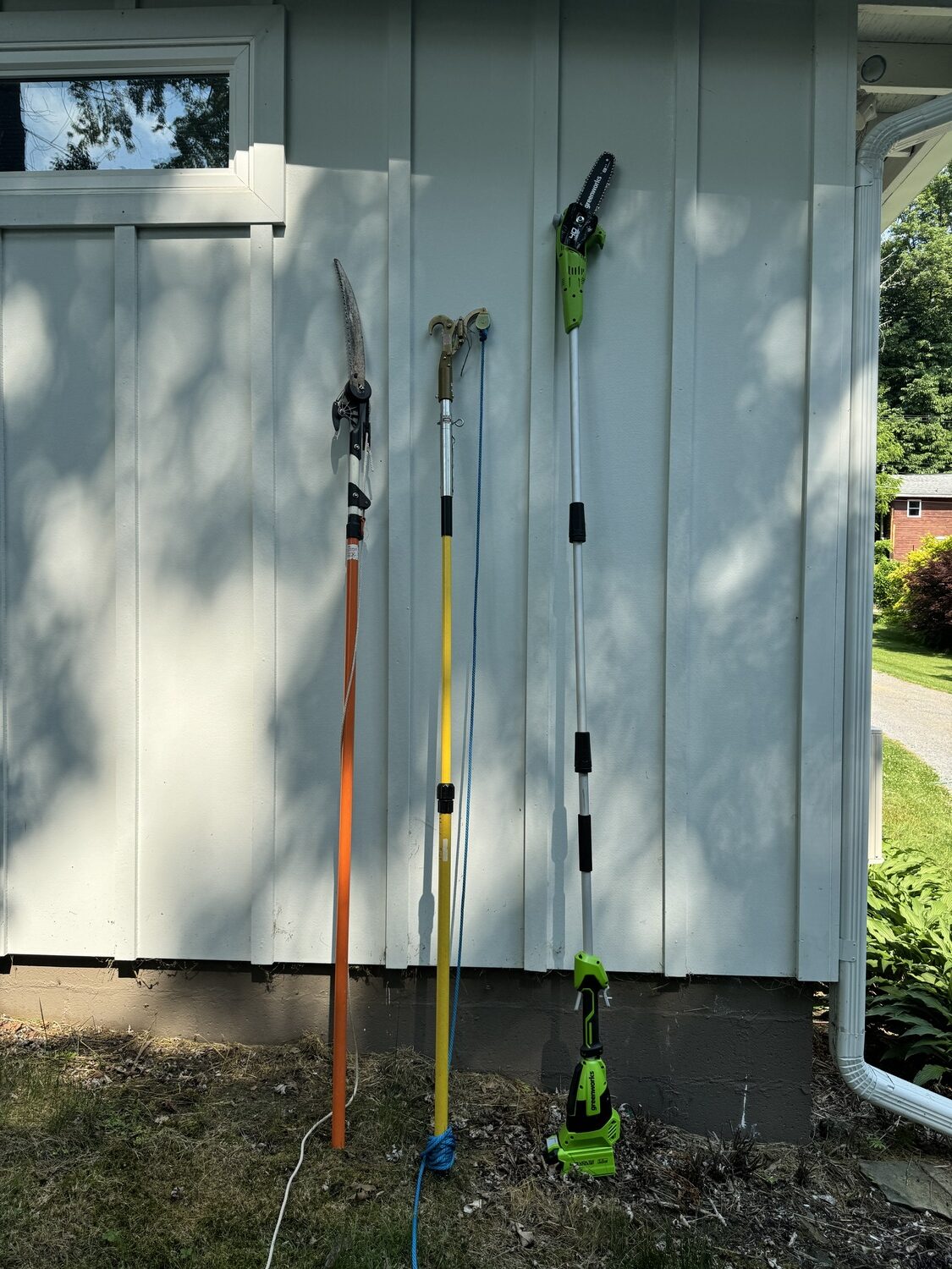 From left, a pole pruner with a lopper and a saw blade. Unextended 8 feet and will extend another 4 feet. This runs $100 to $200 for good quality. In the center is an extendible pole lopper only, also extendible another 4 feet. This will run $70 to
$150. On the right is the 40-volt Greenworks PSF303. Extended it’s 9 feet tall and can be shortened by removing one of the extensions. The price is $163 on Amazon with battery and charger. The battery works with other Greenworks tools. ANDREW MESSINGER