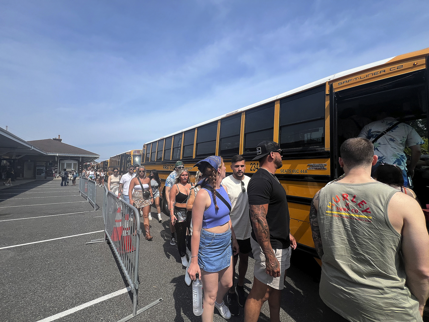 Palm Tree Festival-goers arrive at the Southampton Train Station on Saturday afternoon to line of shuttle buses to take them to the venue on Shinnecock Territory.   DANA SHAW