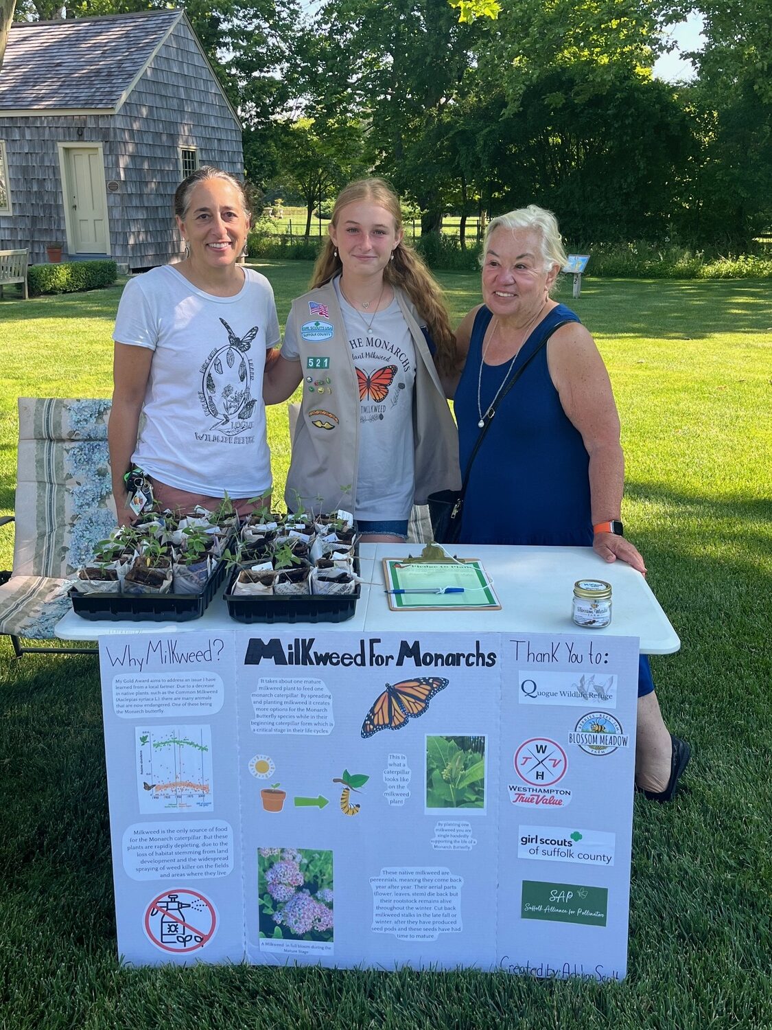 Tour co-chairs Marissa Nelson and Alicia Whitaker flank Girl Scout Adelina Scott as the Quogue Library, as she gave out the milkweed plants she had grown —  a critical source of nectar and pollen for endangered monarch butterflies. COURTESY WESTHAMPTON GARDEN CLUB