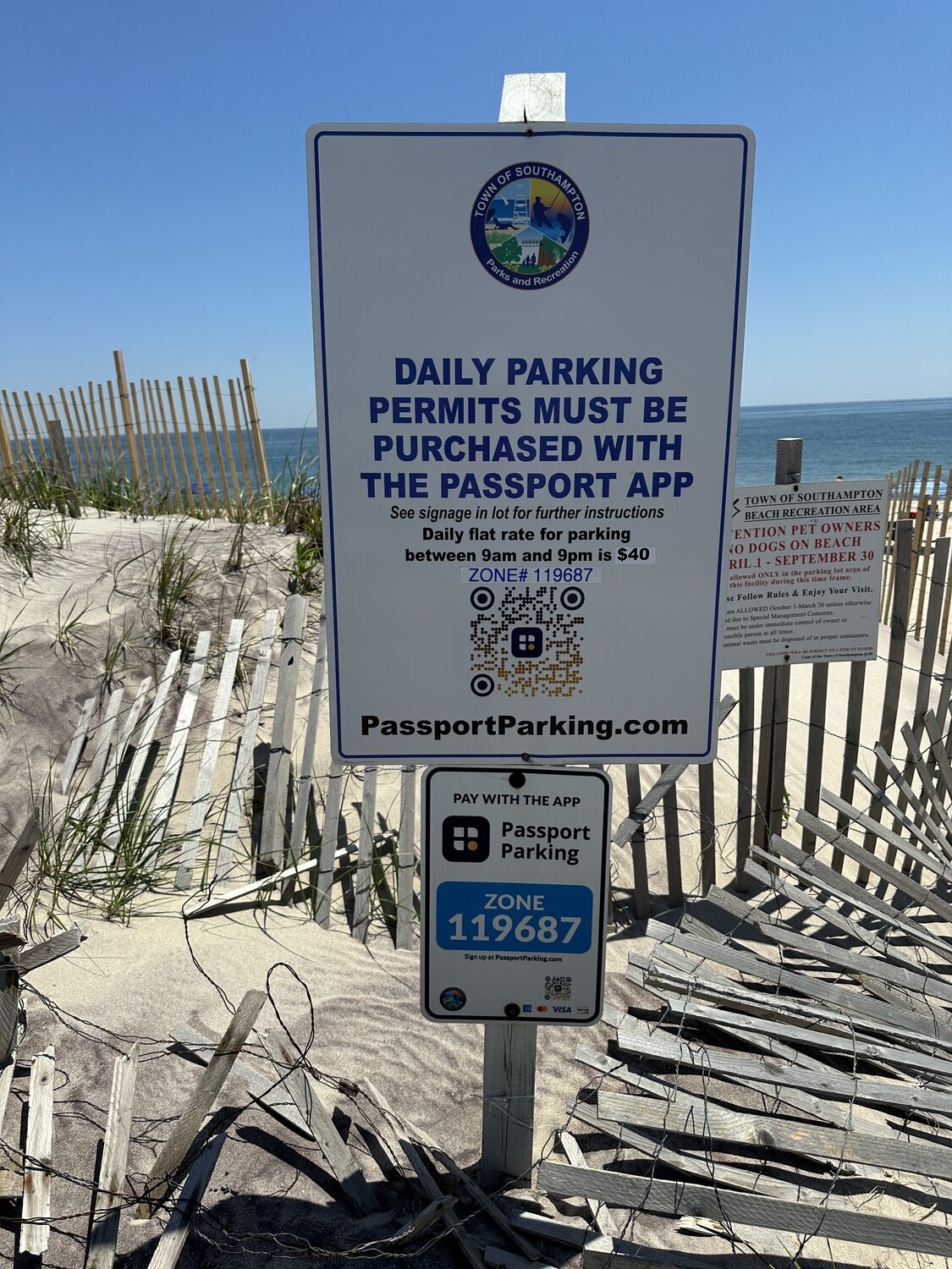 A sign showing the QR code to scan to buy daily parking passes near the pavilion at Tiana Beach. DAN STARK