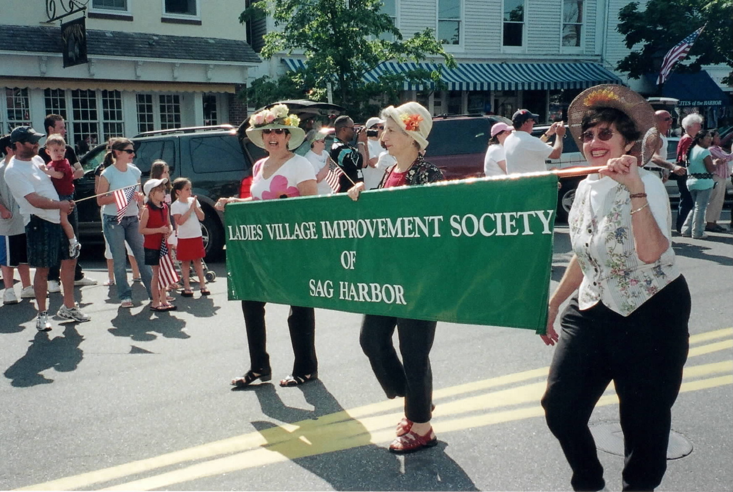 Diane Lewis, Margaret Bromberg and Ann Lieber, from left, carry the LVIS banner in a Sag Harbor parade. COURTESY BETHANY DEYERMOND
