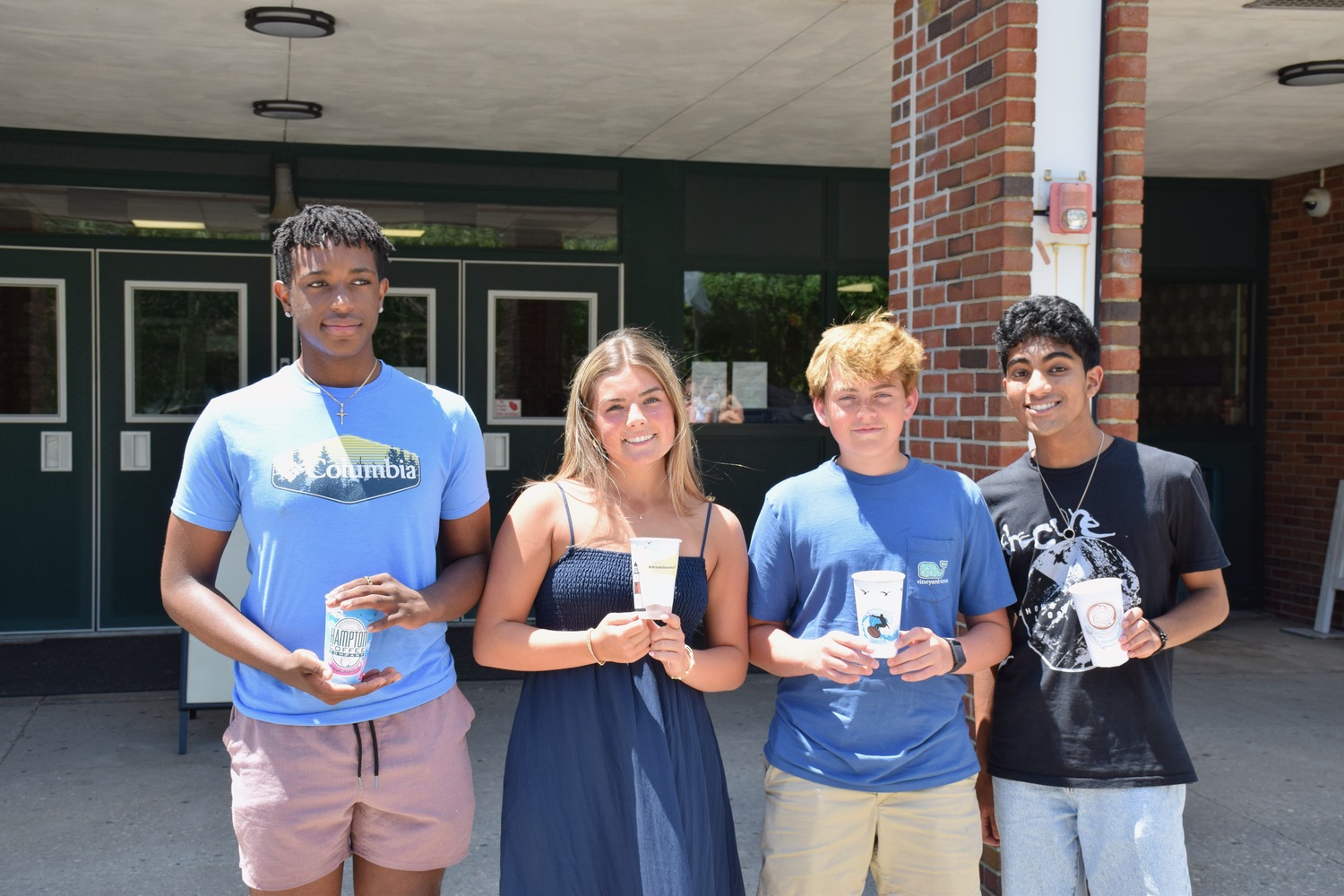 The designs and slogans of five Westhampton Beach High School students, including those of, from left, Donye' Hope, Sienna Macdonald, Jayden Valenti and Luke Albert, are now featured on coffee cups at Hampton Coffee in Westhampton Beach. COURTESY WESTHAMPTON BEACH SCHOO L DISTRICT