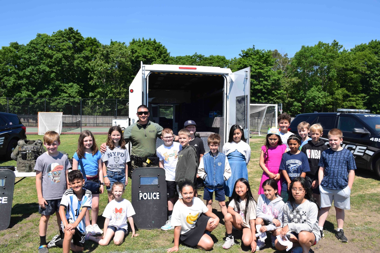 Southampton Town Police Department Emergency Services Officer Chris Manzello with Eastport-South Manor students, during the district's recent Police Day event, during which students learned about law enforcement and emergency services from local agencies. COURTESY EASTPORT-SOUTH MANOR SCHOOL DISTRICT