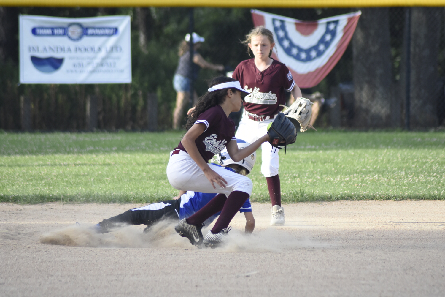 East Hampton shortstop Evie Sanders tries to apply a tag to a Riverhead base runner.   DREW BUDD