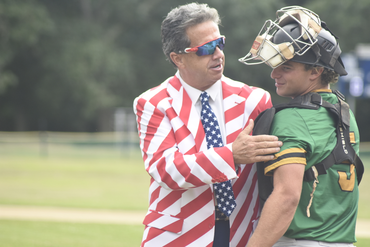 Bill Evans gives Jake Acker a pat on the back for catching his first pitch.   DREW BUDD