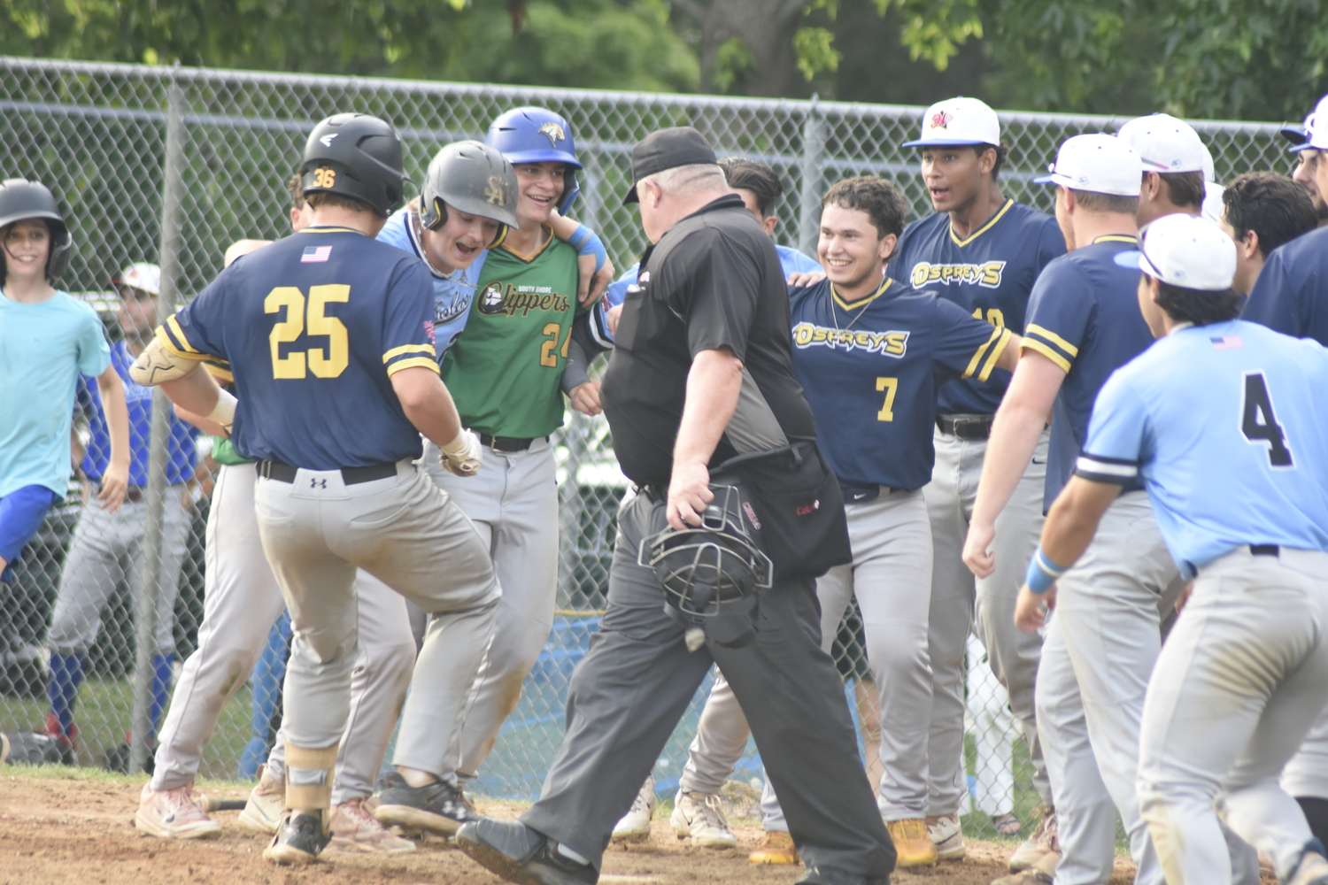 The Blue Team mobs Nick Pratt after his three-run home run won the game for them.  DREW BUDD