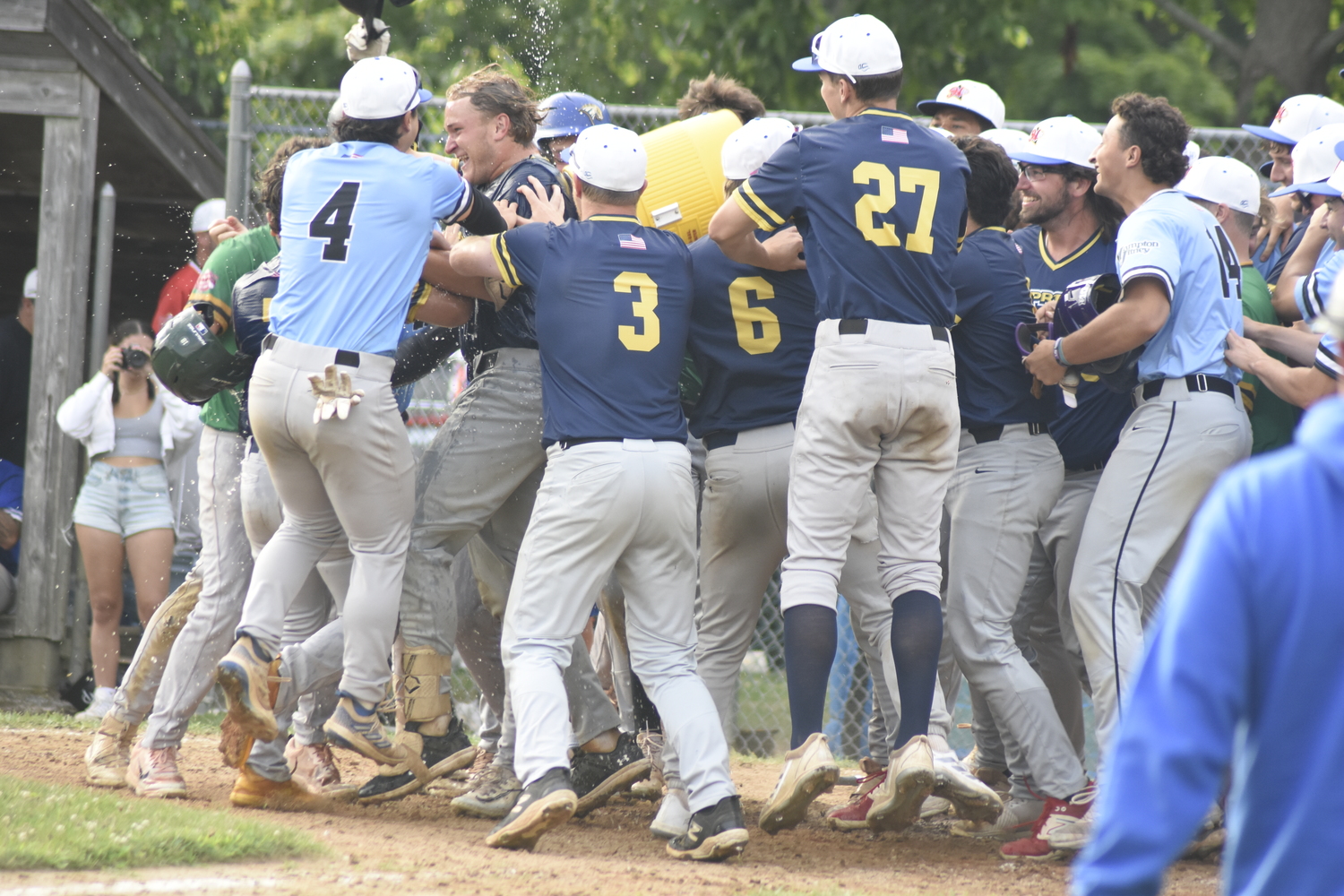 Nick Pratt's Blue Team All-Star teammates douse him in water at home plate.  DREW BUDD