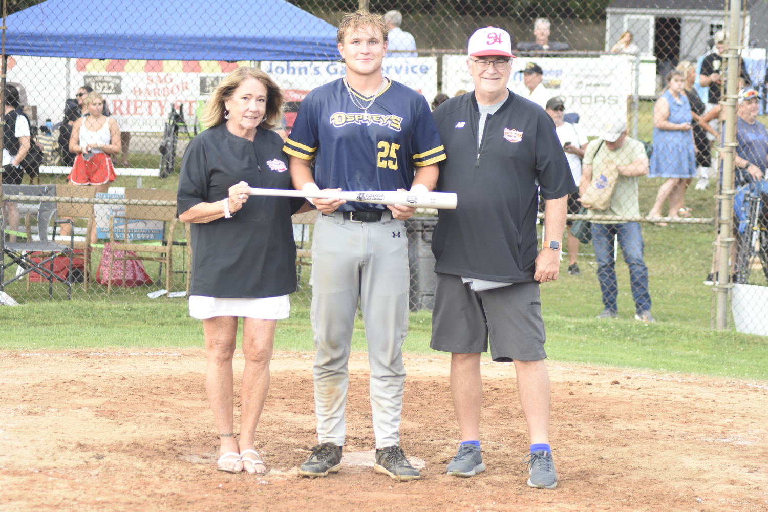 Nick Pratt (Maryland-Baltimore), flanked by HCBL President Sandi Kruel and commissioner Henry Bramwell, was named All-Star Game MVP after his walk-off three-run homer won it for the Blue Team.  DREW BUDD