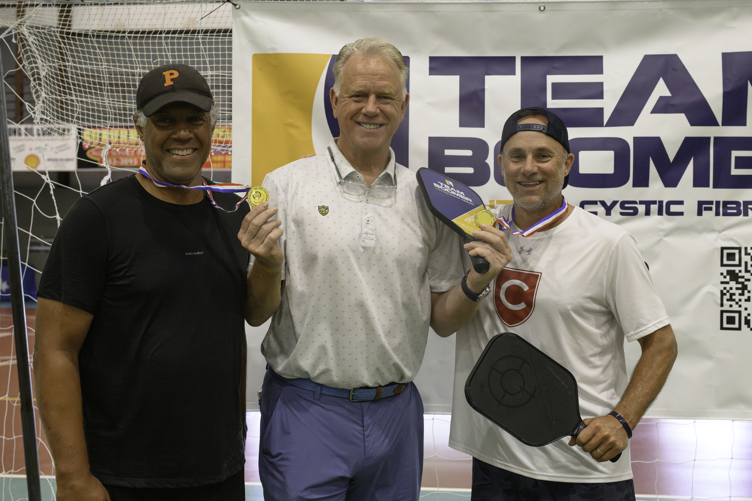 Boomer Esiason with men's doubles champions Chris McGinnis and John Archer.  MARIANNE BARNETT