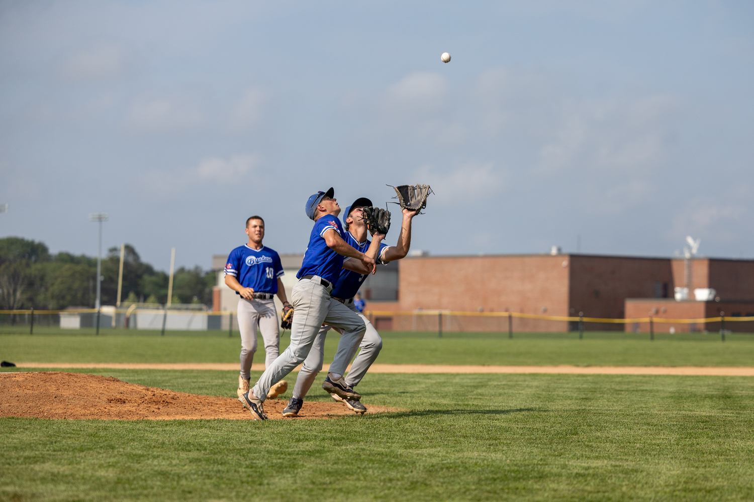 Pitcher Michael Vilardi (Queens College) and third baseman Tim Hennig (Binghamton University) converge on a pop fly in the infield.  RON ESPOSITO