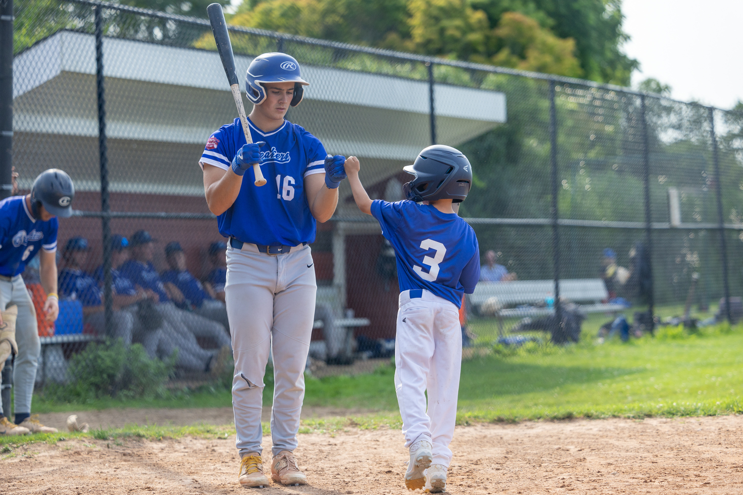 Joseph Frazzetta (New Haven University) gets a fist bump from bat boy James McCarthy .   RON ESPOSITO