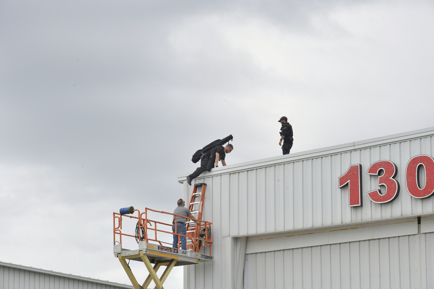 Secret Service climbs to the top of the Modern Aviation building at Gabreski Airport in preparation of the arrival of President Joe Biden on Saturday.  DANA SHAW