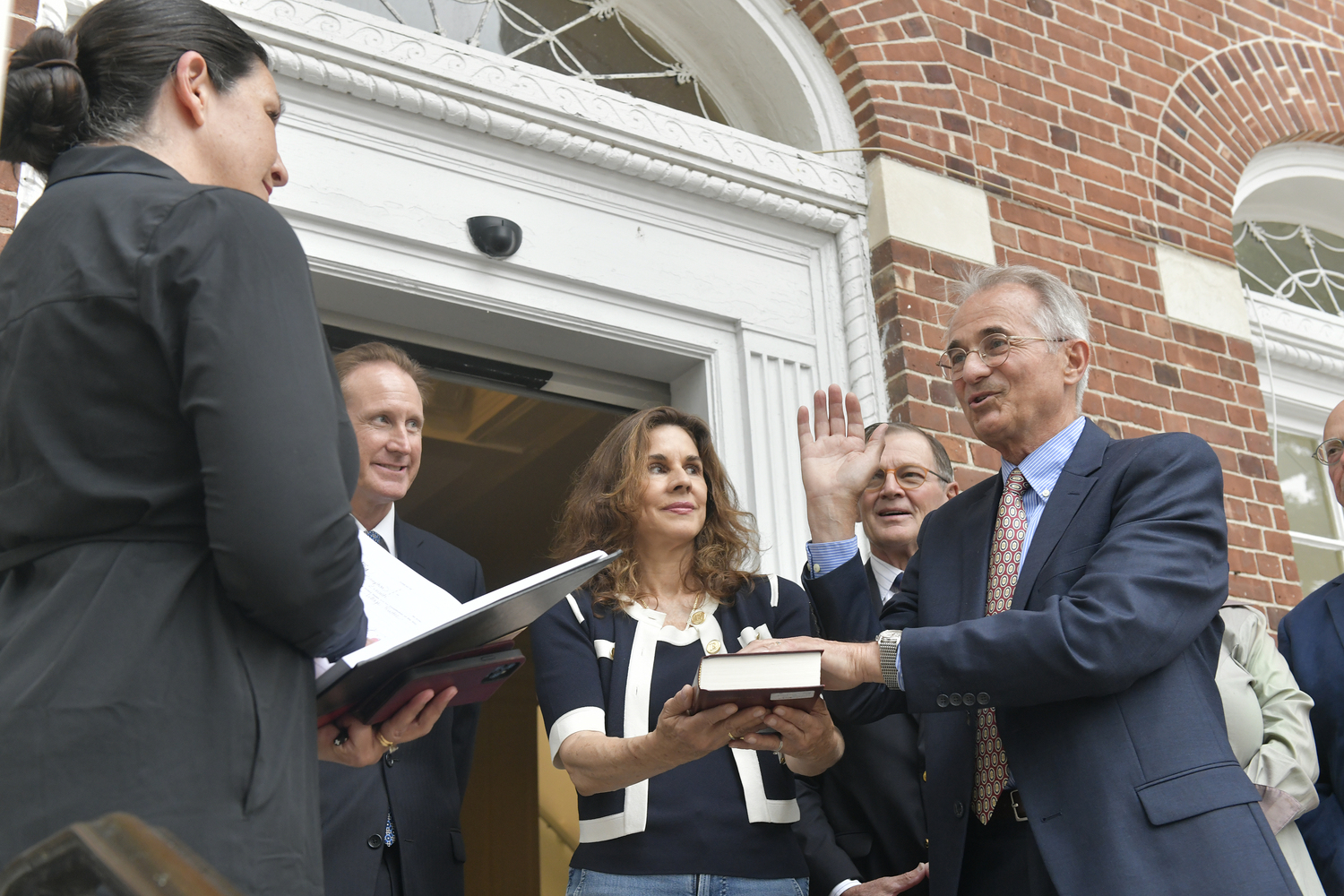 New Southampton Village Trustee Ed Simioni is sworn in by village clerk Cathy Sweeney. on the steps of village hall on Tuesday. Kimberly Allan holds the Bible.  DANA SHAW