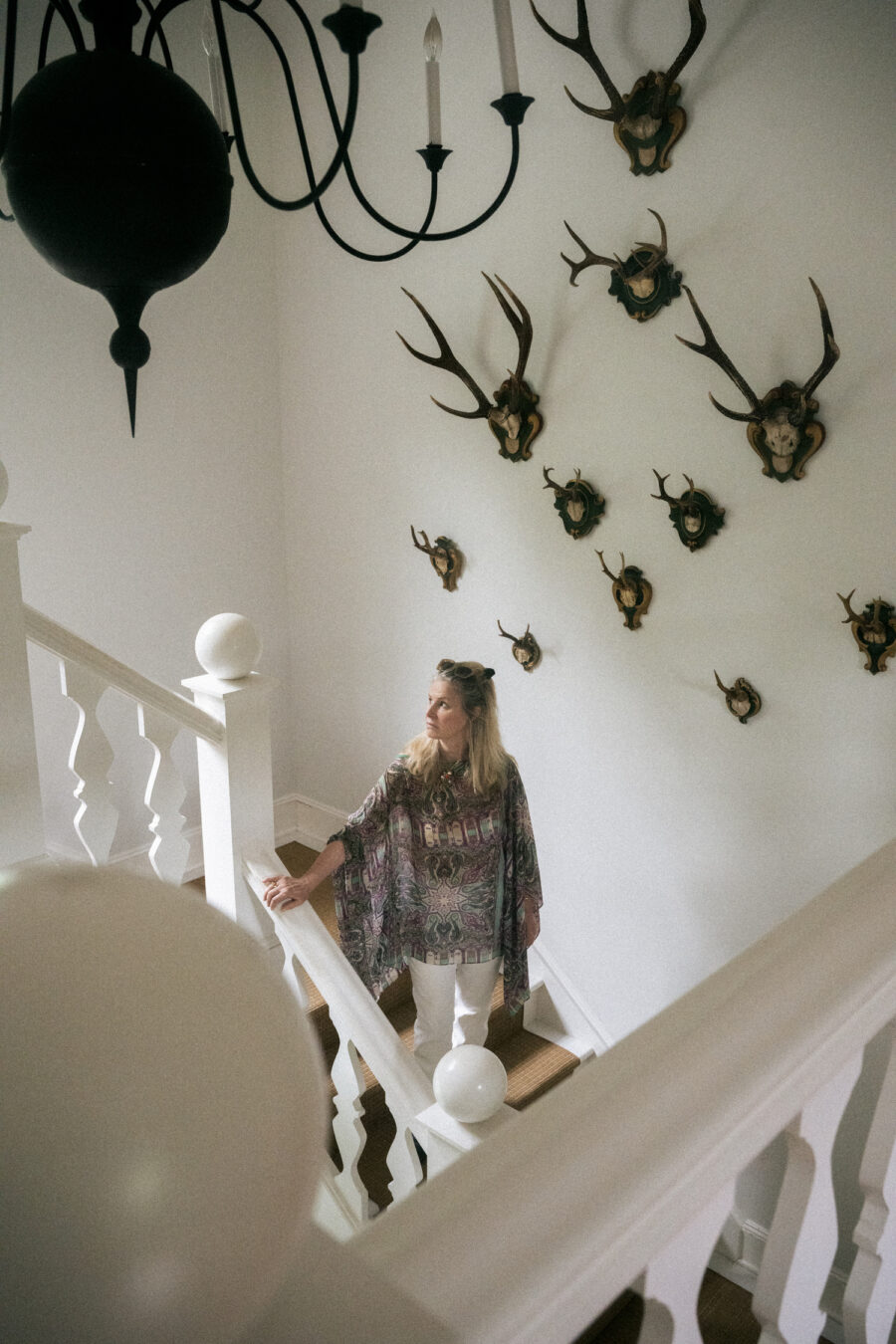 Andrea Karambelas stands proudly on the vast staircase among a sea of mounted vintage antlers. MACRAE MARRAN