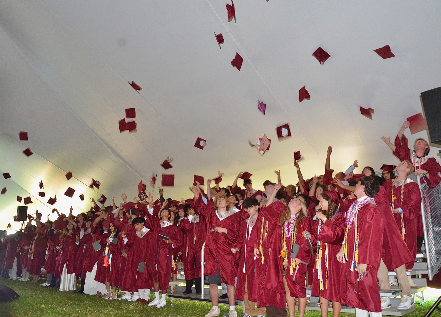 Members of the East Hampton Class of 2024 toss their caps after graduating on June 28.  KYRIL BROMLEY