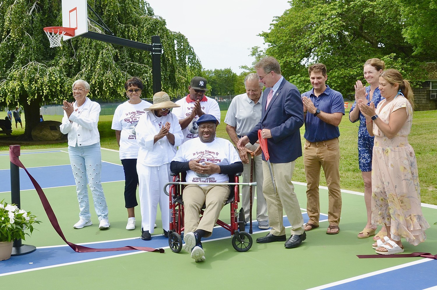 Family, friends, the current and former mayor of East Hampton Village and members of the village board gathered around Gilbert Mabery during the dedication of the Roy Lee Mabery Memorial Courts on Saturday. KYRIL BROMLEY