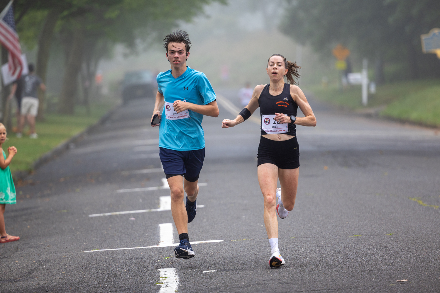 Aileen Barry, this year's women's 8K champion, running alongside Jake Cook of Southampton, who was taking part in the 3-mile race.   RON ESPOSITO