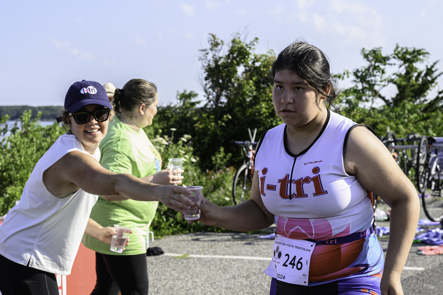 A volunteer hands water to Leah Tejeda of Wainscott.   MARIANNE BARNETT