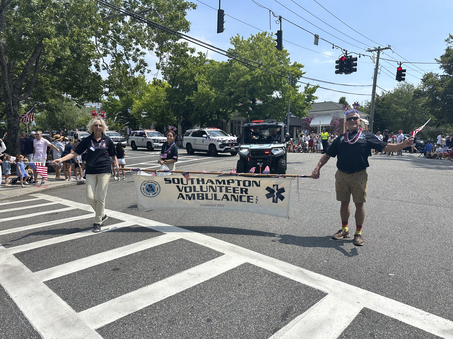 Adele Kristiansson and Jimmy Mack hold up the Southampton Volunteer Ambulance sign at the Southampton Fourth of July Parade.  GREG D'ELIA