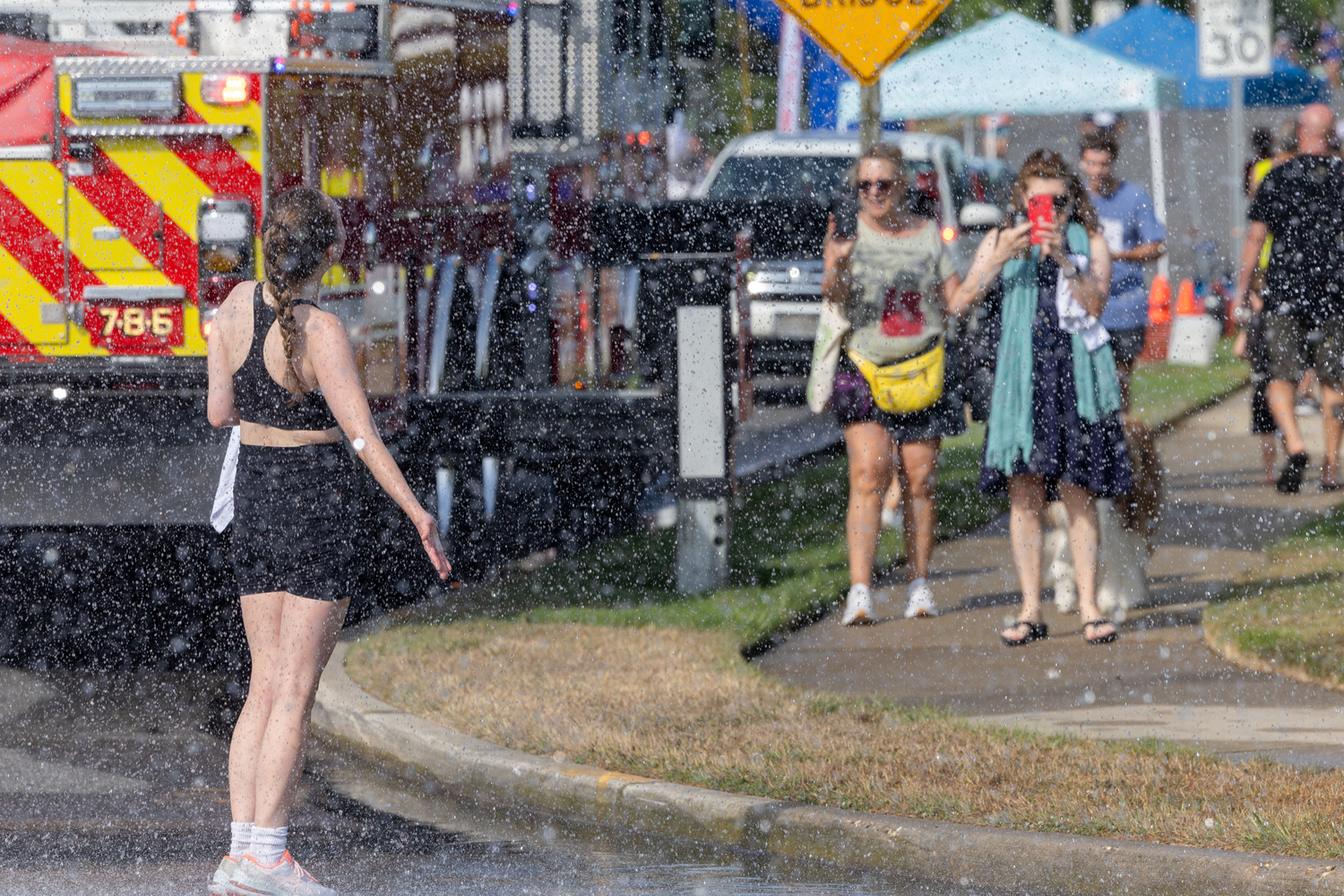 The postrace shower provided by the Westhampton Beach Fire Department has many uses, insta shots being one of them.   RON ESPOSITO