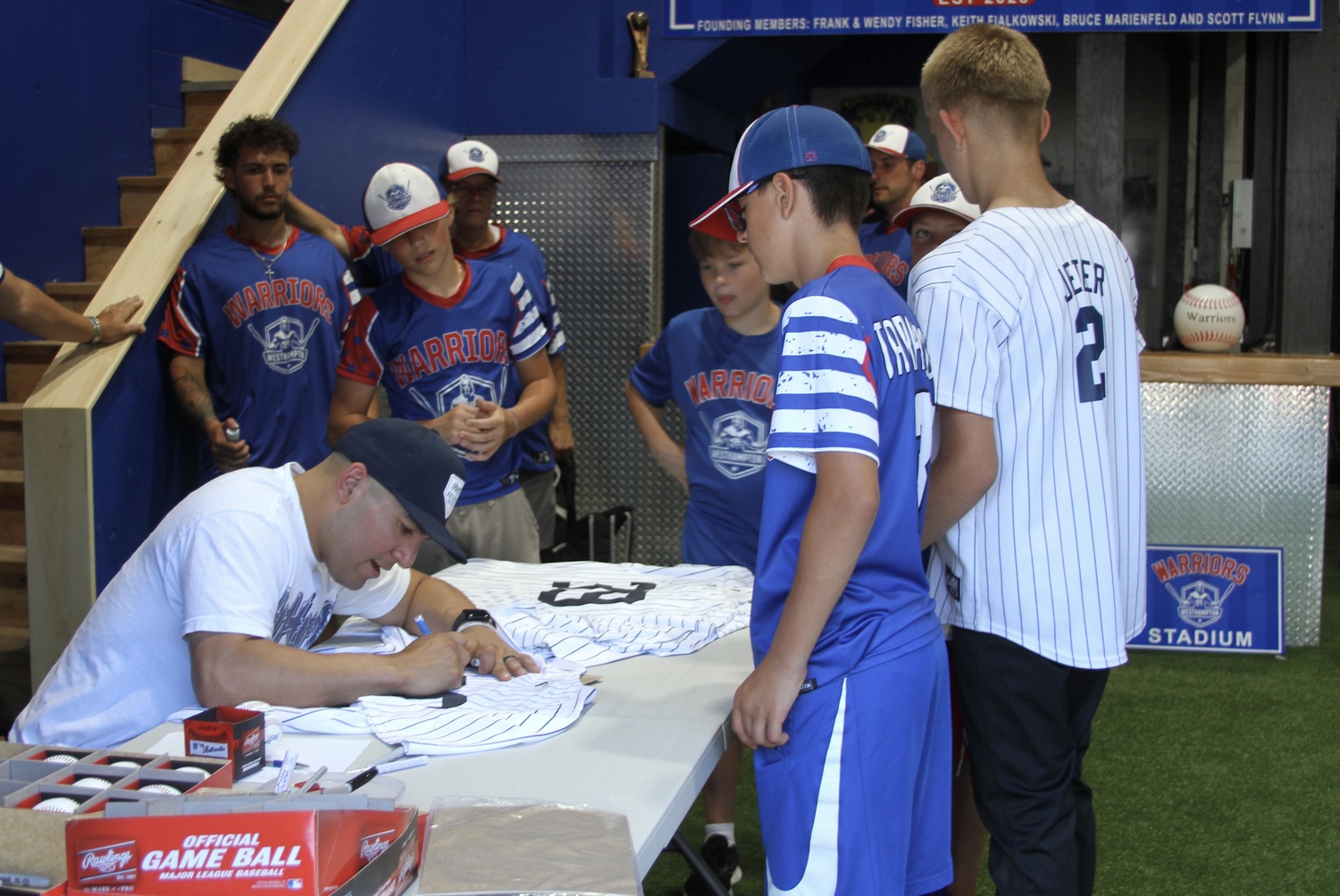 New York Yankees catcher Jose Trevino signs jerseys and baseballs he brought as gifts for members of the Westhampton Warriors 12U baseball team during a surprise visit to their Riverhead training facility July 1. DESIRÉE KEEGAN