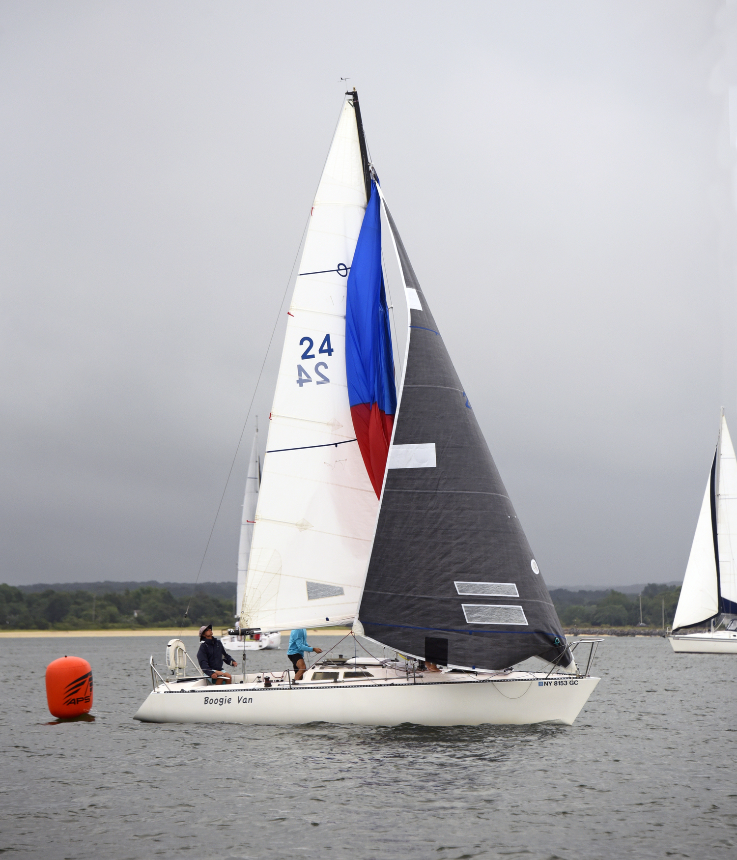 First place Division 2 Boogie Van, skippered by Jody Locascio, drops her chute in preparation for the upwind start as light rain falls.   MICHAEL MELLA