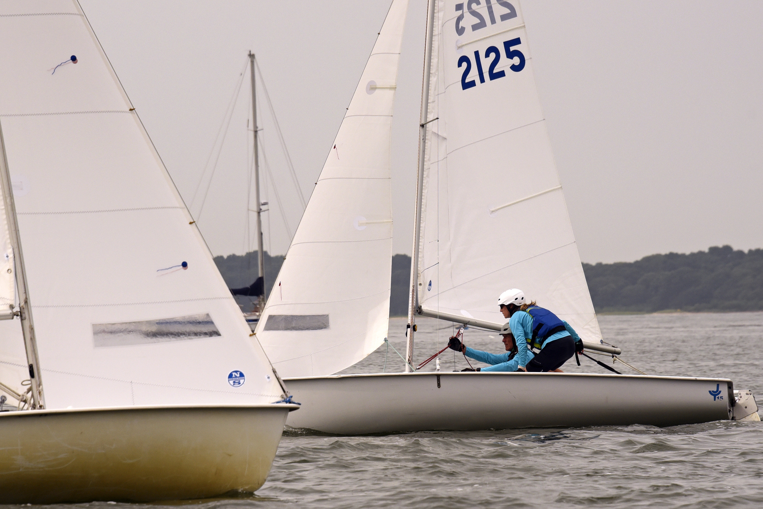 Jenny Theiss, up on her feet to carefully navigate her burdened port-tack boat past a privileged starboard-tack boat, while Bud Rogers, BYC’s former commodore, continually passes along his cogent advice to her. MICHAEL MELLA