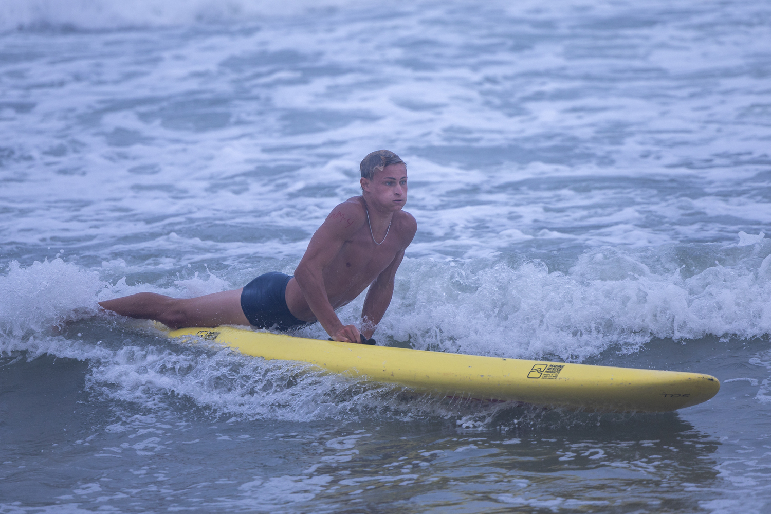 Bryan Schoerlin rides a wave in during the paddle board relay.   RON ESPOSITO