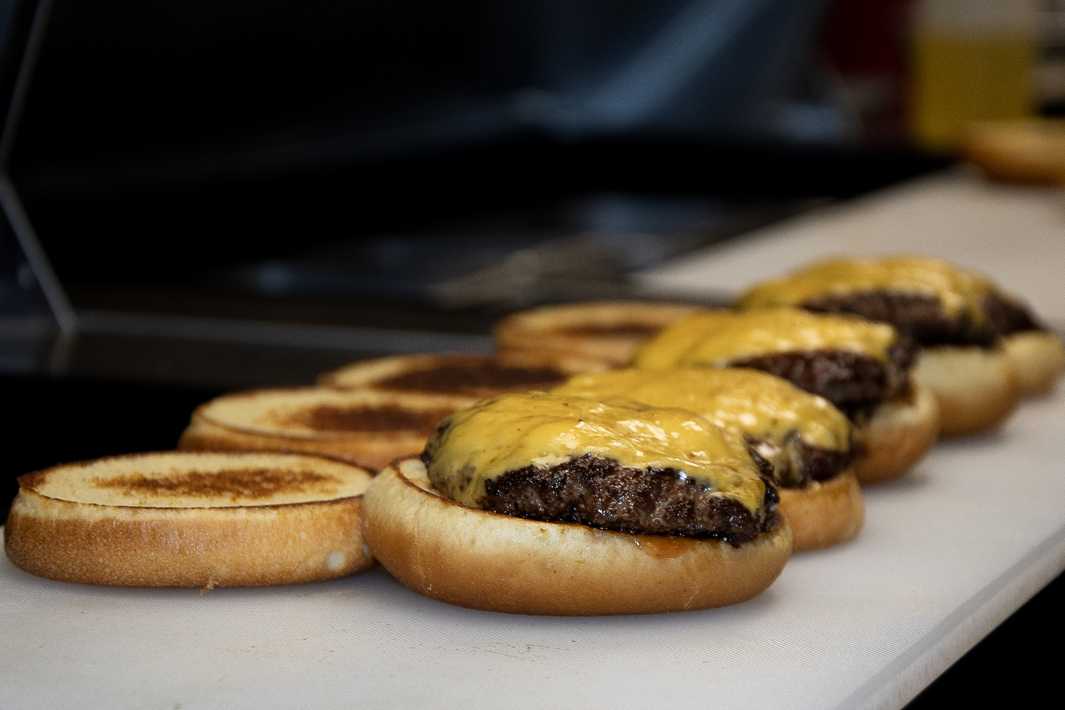 Smokey Buns cheeseburgers on the grill. The new restaurant officially opens in East Hampton on July 25. COURTESY SMOKEY BUNS