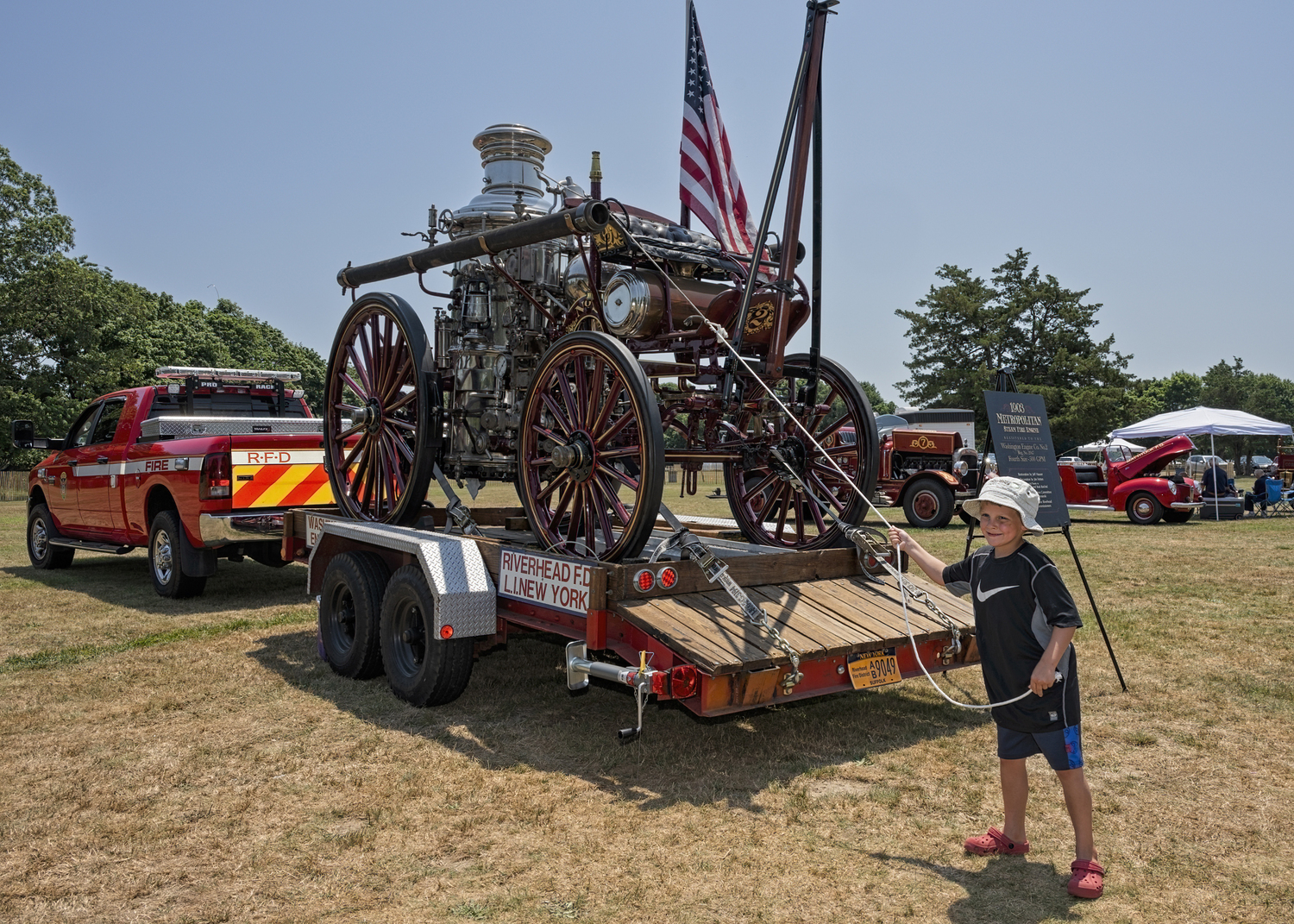 Five and a half year old Daniel Williams of Sayville got to ring the bell of the Riverhead Fire Department’s 1903 Metropolitan steam engine at the Greater Westhampton Historical Museum's antique fire apparatus exhibition on the Great Lawn in Westhampton Beach on Sunday. COURTESY GREATER WESTHAMPTON HISTORICAL MUSEUM